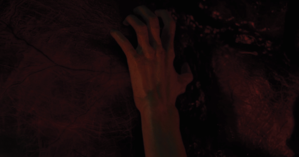 A screenshot from Amityville: The Awakening showing a sinister hand within the Red Room